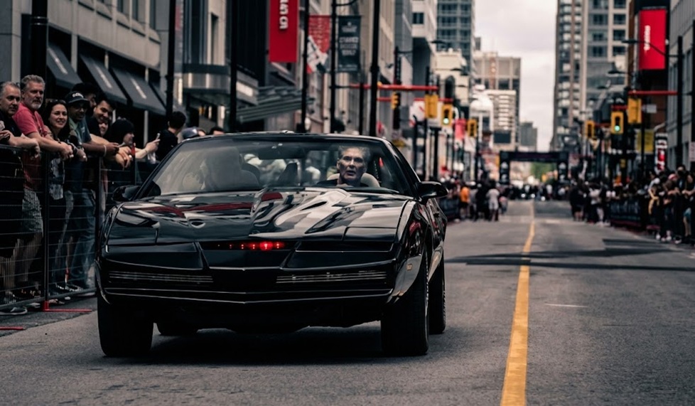 David Hasselhoff driving the KITT replica car down a busy downtown Toronto street